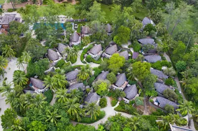 an overhead view of a resort with trees and huts at Renaissance Phuket Resort & Spa in Mai Khao Beach