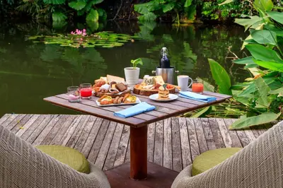 a table with food on it next to a body of water at Renaissance Phuket Resort & Spa in Mai Khao Beach