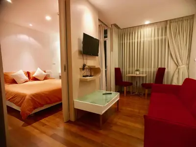 a hotel room with a bed and a red couch at Art Patong by Moloko in Patong Beach