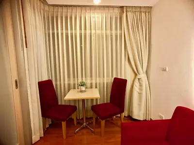 a room with a table and two red chairs and a window at Art Patong by Moloko in Patong Beach