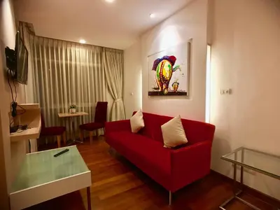 a living room with a red couch and a table at Art Patong by Moloko in Patong Beach