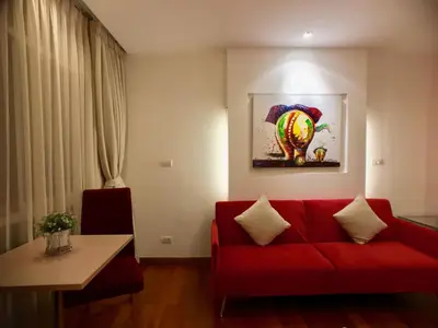 a living room with a red couch and a table at Art Patong by Moloko in Patong Beach