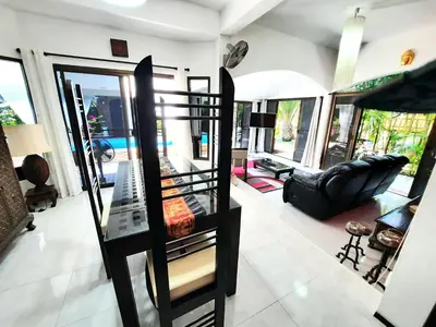 a living room with a black chair and a couch at Bjou, Cosy Tropical Villa in Rawai Beach