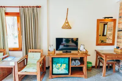 a living room with a tv and a table and chairs at Krabi Sands Resort in Klong Muang Beach