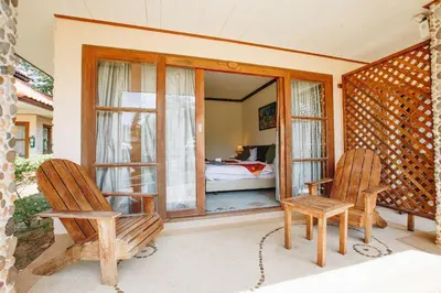 a room with two chairs and a bedroom with a bed at Krabi Sands Resort in Klong Muang Beach
