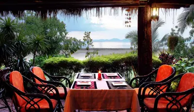 a table and chairs with a view of the ocean at Krabi Sands Resort in Klong Muang Beach