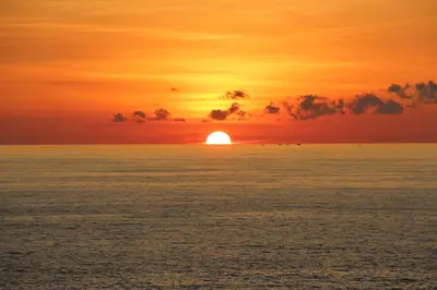 a sunset over the ocean with the sun setting at Ayara Kamala Resort & Spa - SHA Extra Plus in Kamala Beach