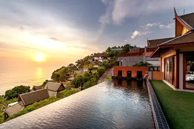 a villa with a view of the ocean at sunset at Ayara Kamala Resort & Spa - SHA Extra Plus in Kamala Beach
