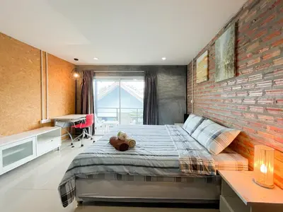 a bedroom with a bed with a teddy bear on it at The Endless Bangtao Residence LOFT 9 in Bang Tao Beach