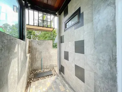 a bathroom with a stone wall with a window at The Endless Bangtao Residence LOFT 9 in Bang Tao Beach