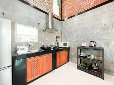 a kitchen with a black counter and a refrigerator at The Endless Bangtao Residence LOFT 9 in Bang Tao Beach