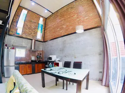 a kitchen with a table in the middle of a room at The Endless Bangtao Residence LOFT 9 in Bang Tao Beach