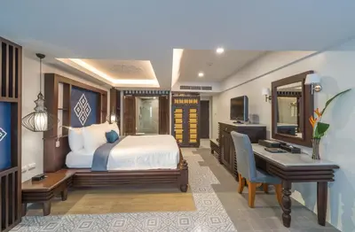 a bedroom with a bed and a desk and a desk at Aonang Princeville Villa Resort & Spa - GHA WellHotel-Halal Certified, Krabi, Thailand in Ao Nang Beach