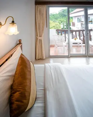 a bedroom with a bed and a view of a patio at Aonang Sunset Hotel - SHA Extra Plus in Ao Nang Beach