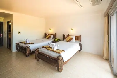 two beds in a room with white walls at Aonang Sunset Hotel - SHA Extra Plus in Ao Nang Beach