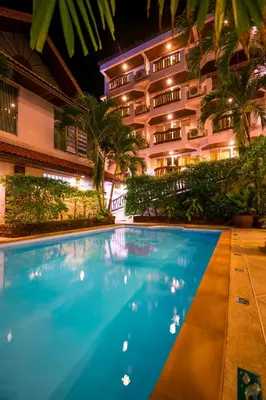 a hotel with a swimming pool in front of a building at Aonang Sunset Hotel - SHA Extra Plus in Ao Nang Beach
