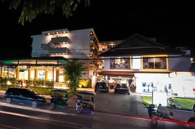 a building with cars parked in front of a street at Aonang Sunset Hotel - SHA Extra Plus in Ao Nang Beach