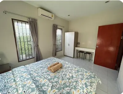 a bedroom with a bed with a blue blanket and a desk at The Endless Bangtao Residence TV2 AND TV 3 in Bang Tao Beach