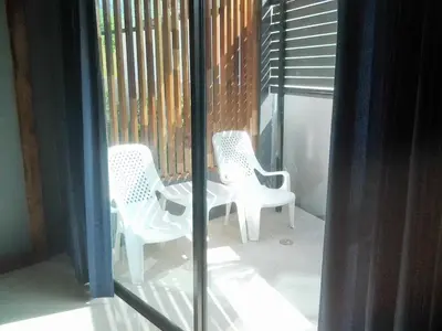 two white chairs sitting on a balcony at The Endless Bangtao Residence CAC 4 in Bang Tao Beach