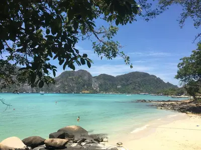 a beach in the philippines with mountains in the background at Bayview Resort Phi Phi Island - Beach Front Resort in Phi Phi Don