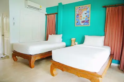 two white beds in a room with green walls at Bayview Resort Phi Phi Island - Beach Front Resort in Phi Phi Don