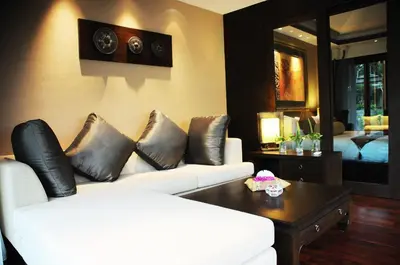 a living room with a white couch and a table at Niramaya Villa & Wellness in Ko Yao Noi