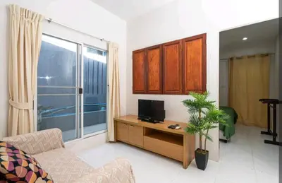 a living room with a couch and a tv on a table at The Endless Bangtao Residence ST2 in Bang Tao Beach