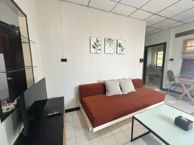 a living room with a couch and a tv at The Endless Bangtao Residence CAC 1 in Bang Tao Beach