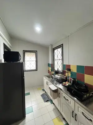 a kitchen with a black refrigerator in a room at The Endless Bangtao Residence CAC 1 in Bang Tao Beach