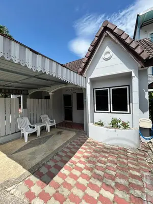 a white house with two white chairs on a patio at The Endless Bangtao Residence PM12 in Bang Tao Beach