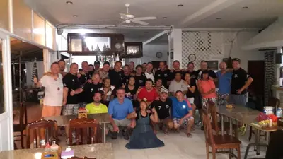 a group of people posing for a picture in a room at Tony Home and Restaurant in Karon Beach