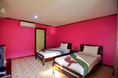 two beds in a room with pink walls at Sand Sea House in Phi Phi Don
