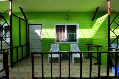 a green house with a table and two chairs at Sand Sea House in Phi Phi Don