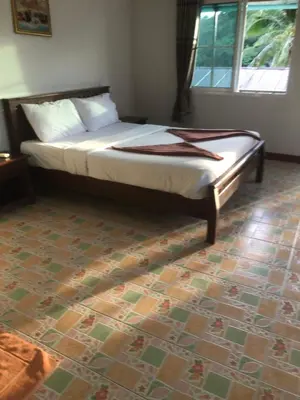 a bed sitting in a bedroom with a floor at Sand Sea House in Phi Phi Don