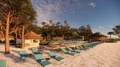a row of chaise lounges and chairs on a beach at OUTRIGGER Phi Phi Island Resort in Phi Phi Don