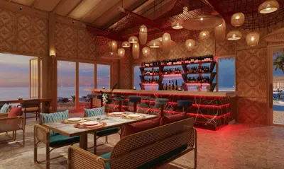 a restaurant with a table and chairs and a bar at OUTRIGGER Phi Phi Island Resort in Phi Phi Don