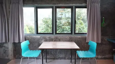a wooden table with blue chairs in front of a window at The Endless Bangtao Residence CHAT 2 in Bang Tao Beach