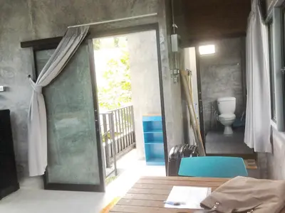 a room with a door leading to a bathroom with a toilet at The Endless Bangtao Residence CHAT 2 in Bang Tao Beach