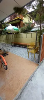 a patio with a table and an umbrella and benches at The Endless Bangtao Residence VC 1 in Bang Tao Beach