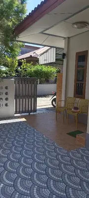 a patio with two chairs and a table on a rug at The Endless Bangtao Residence VC 1 in Bang Tao Beach