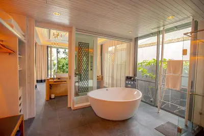 a large bathroom with a tub and a large window at Baba Beach Club Phuket Natai Luxury Pool Villa Hotel by Sri panwa in Natai Beach