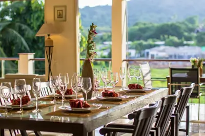 a long table with wine glasses on top of it at Viola Pool Villa Elegant Elegant Villa In Paradise in Rawai Beach