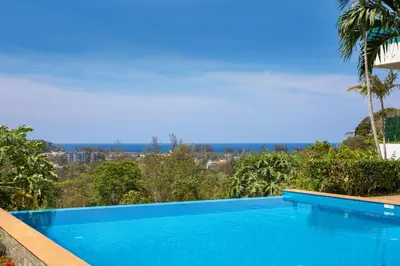 a blue swimming pool with a view of the city at Baan Chom View Kamala - SHA Plus in Kamala Beach