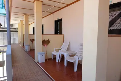 a hallway with two white chairs and a table at Phi Phi Sand Sea View Resort in Phi Phi Don
