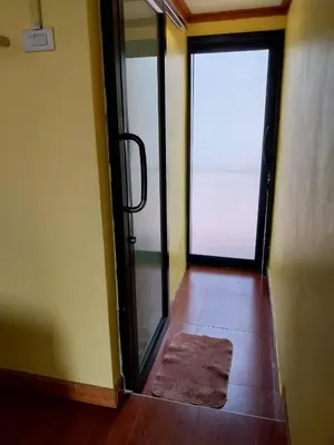 a bathroom with a glass door and a rug on the floor at Phi Phi Sand Sea View Resort in Phi Phi Don