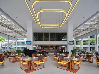 a lobby with tables and chairs and a chandelier at The Kee Resort & Spa in Patong Beach