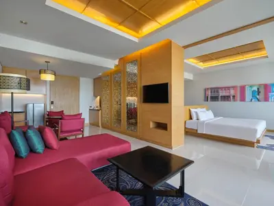 a living room with a couch and a bed at The Kee Resort & Spa in Patong Beach