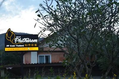 a sign in front of a building with a tree at Phitharom PP Resort in Phi Phi Don