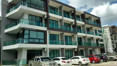 a building with cars parked in front of it at Naithon condominium A-103 in Nai Thon Beach
