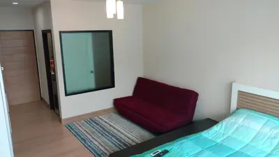 a bedroom with a bed and a red chair at Naithon condominium A-103 in Nai Thon Beach